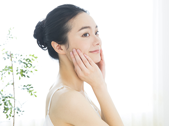 顔を触っている女性